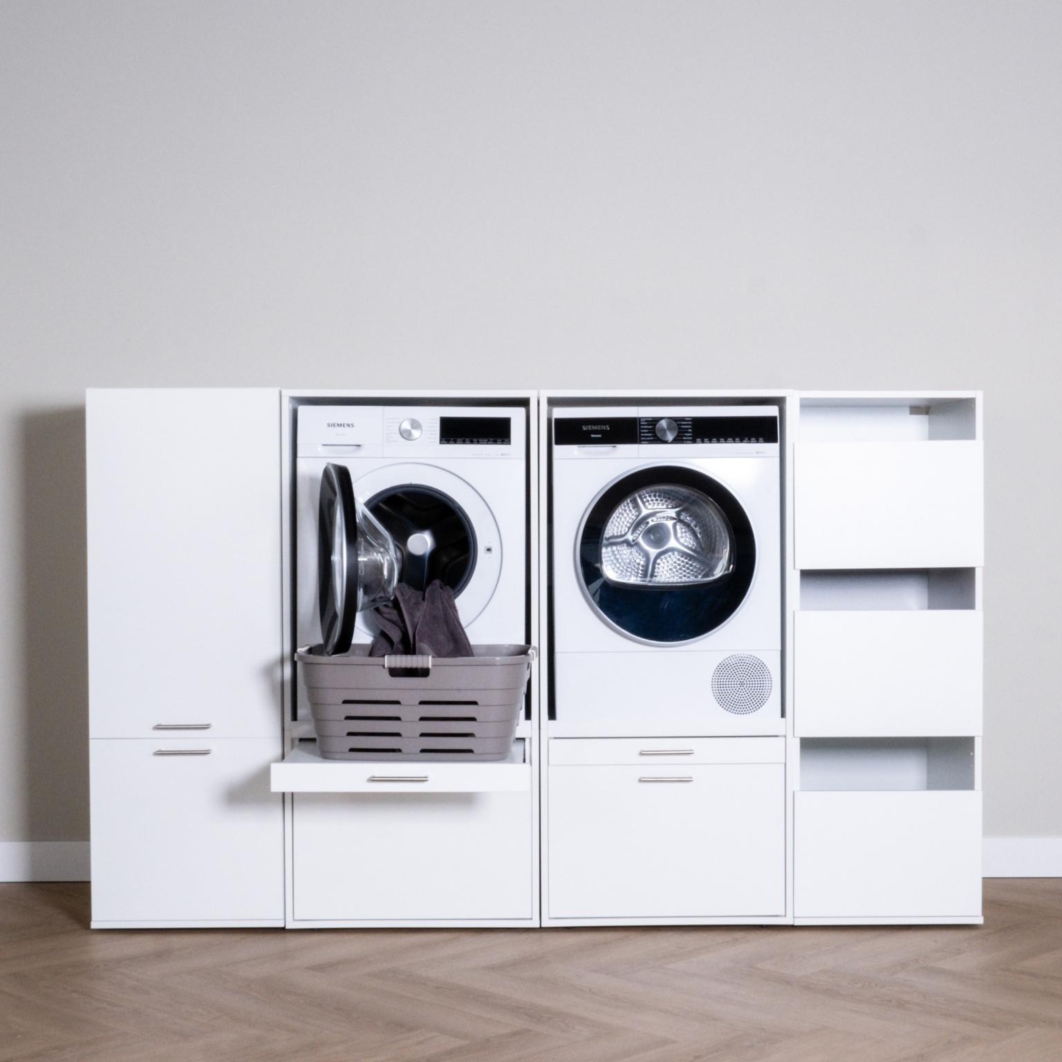 White modern laundry cabinet set with front-load washer, dryer, and open shelving.