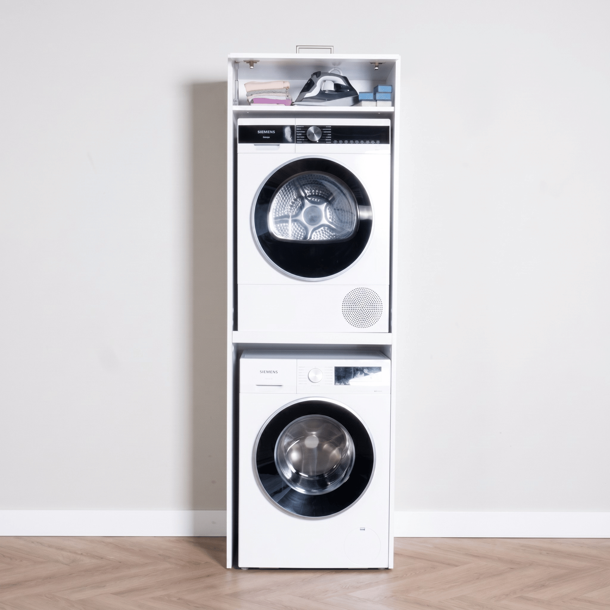 Stacked white front-load washer and dryer set with digital displays on a light background.