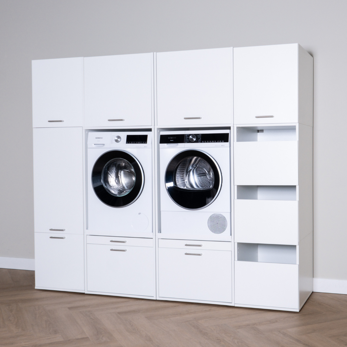 White modular laundry cabinet set with front-loading washer and dryer, shelves, and drawers.