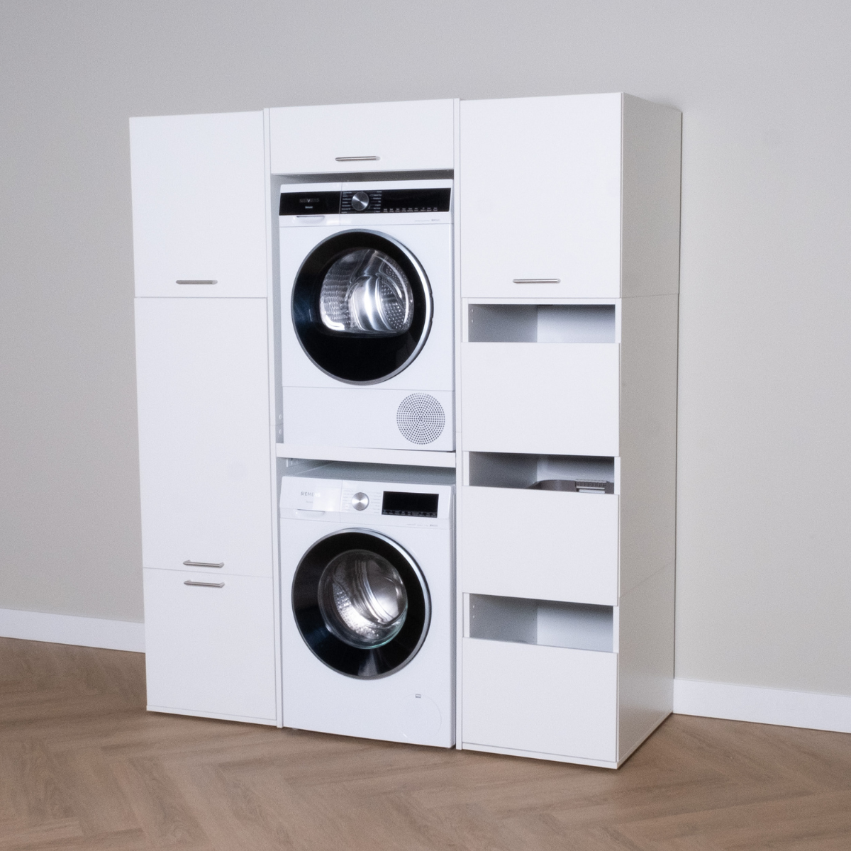 White modular laundry stack set with front-load washer and dryer, integrated storage cabinets and open shelves.