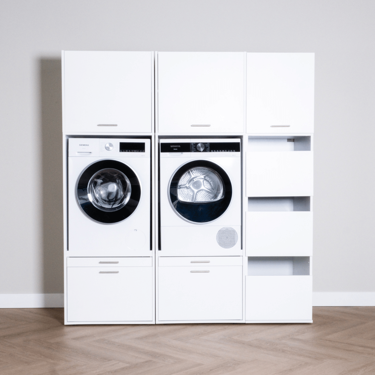 White laundry cabinet set with front-load washer, dryer, and open shelving unit.